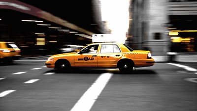 平移摄影的黄色出租车在公路上
